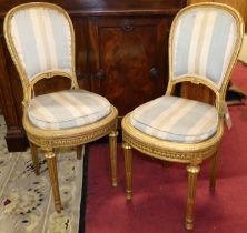 A pair of 19th century French gilt wood salon side chairs, each in the Louis XVI taste, with striped