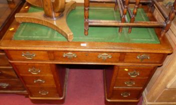 A Victorian oak round cornered twin pedestal writing desk, having a gilt-tooled green leather