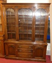 A contempoary oak bookcase, with three glazed upper doors over a base fitted with drawers and