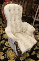 A mid-Victorian mahogany framed gent's spoonback armchair, having cream floral needlework button