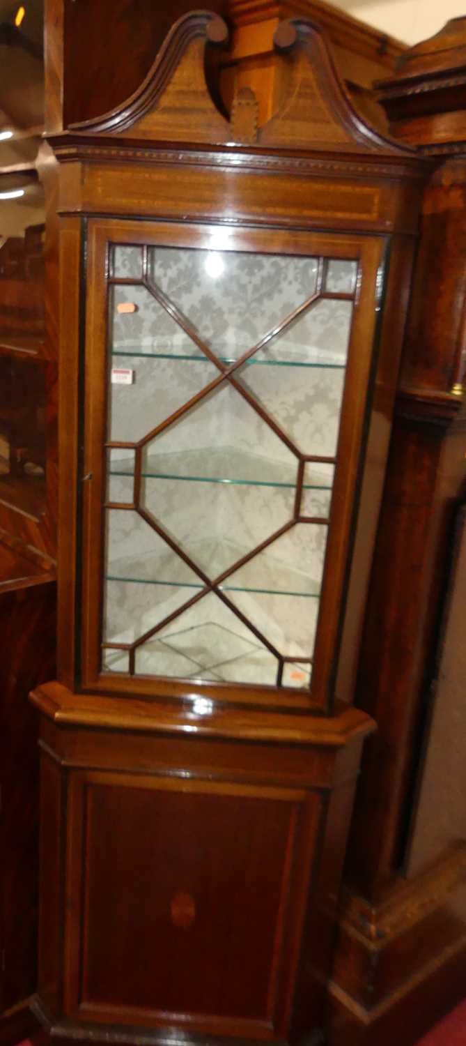 An Edwardian mahogany and satinwood inlaid freestanding corner cupboard, having astragal glazed