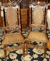 A pair of 19th century provincial carved walnut cane back and seat dining chairs, each in the