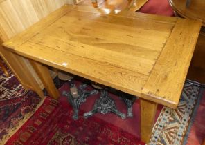 A contemporary joined light oak rectangular dining table, having cleated ends and raised on square