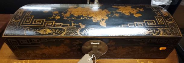 A Chinese black lacquered and floral gilt decorated domed hinge top table box, having brass end