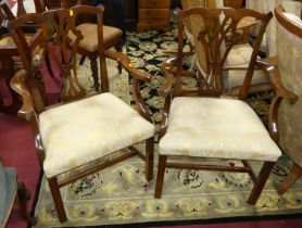 A pair of mahogany Chippendale style open elbow chairs, each having cream floral fabric