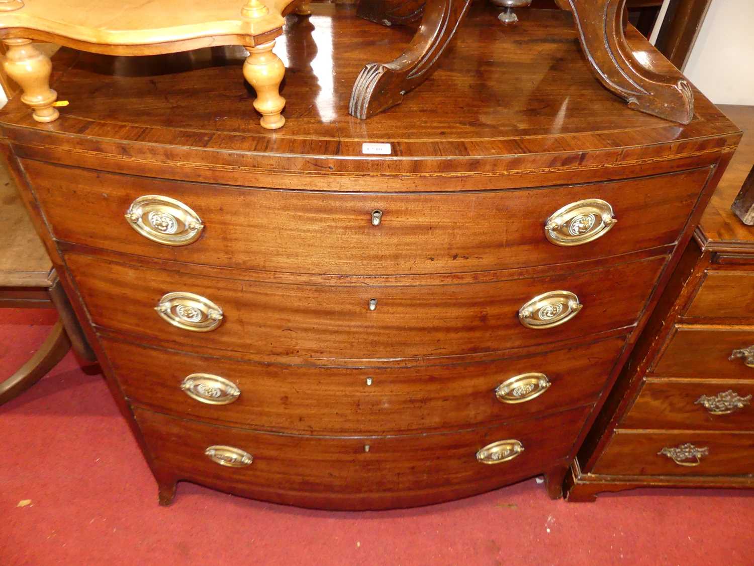 A Regency mahogany, rosewood crossbanded and further inlaid bowfront chest of four long graduated