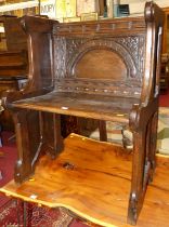 A joined oak ecclesiastical single seat pew, having relief carved panelled back, w.66.5cm