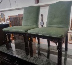 A pair of Chippendale style mahogany and green fabric upholstered dining chairs, each with relief