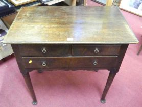 An early 19th century provincial oak three drawer lowboy, having an arrangement of two short over