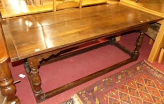 A joined oak and elm plank topped refectory table, having cleated ends, raised on turned and