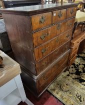 An 18th century walnut and feather banded chest on chest, the upper section with three short drawers