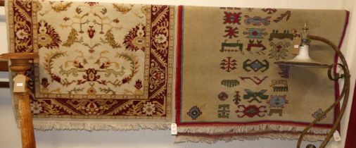 A Persian style cream and red ground woollen rug, 190 x 122cm; together with a tribal rug (2)