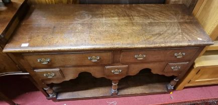 A contemporary joined oak dresser base, in the 18th century taste, having two long and three short