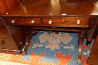 A Regency mahogany sofa table, having rounded drop ends, twin frieze drawers and raised on