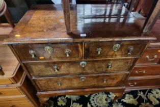 *An antique figured walnut and cross banded chest on later stand, having two short over two long