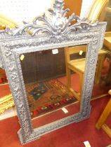 A pine framed floral gesso and later silvered painted rectangular wall mirror, with floral surmount,