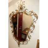 A contemporary floral wired and scroll gilt metal framed shaped wall mirror, in the French taste,