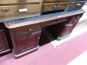 A mid-Victorian mahogany round cornered rexine inset kneehole writing desk, each pedestal with