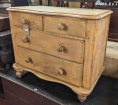 A 19th century pine low chest of two short over two long drawers, raised on turned squat supports