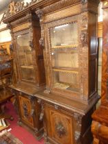 A pair of circa 1900 heavily carved Flemish oak parlour bookcases, each with single glazed upper