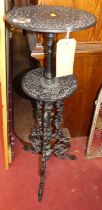 *A black painted pierced cast iron two-tiered plant stand, profusely floral scroll decorated, height
