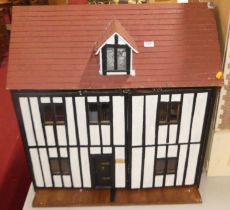 A mock Tudor child's doll's house, the timbered front opening to reveal a roomed interior,