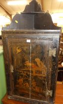 An 18th century provincial chinoiserie black lacquered single door hanging corner cupboard