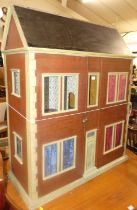 A two-storey dolls house, the twin hinged doors enclosing divisional interior rooms, with pitched