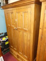A contemporary stained pine double door wardrobe with twin short lower drawers, width 126cm