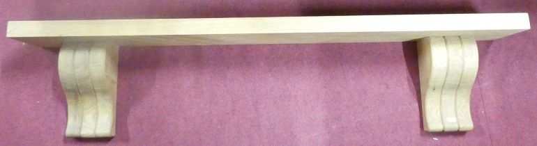 A contemporary well-made blond oak single wall shelf, having slightly shaped supports, length 137.