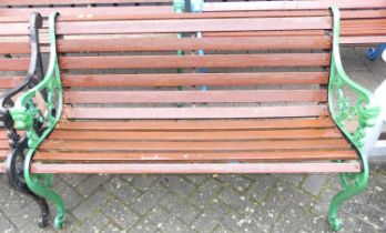 A green painted pierced and cast iron ended and stained slatted wood two-seater garden bench,