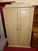 A contemporary cream painted pine double door wardrobe, in the French taste, raised on turned