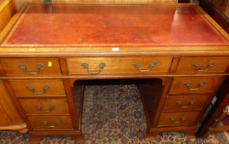 A circa 1900 walnut and gilt tooled burgundy leather inset kneehole writing desk, having typical