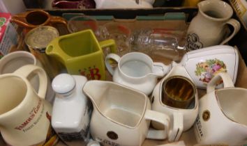 Two fruit trays containing a collection of whisky related advertising jugs, flagons and glassware to