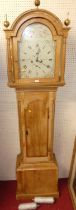 An early 19th century pine long case clock having a painted and gilt decorated arched dial signed