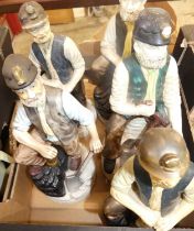 A collection of five various painted composition figural ornaments of coal miners together with a