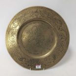 An Eastern brass charger, etched with dragons, dia.41cm