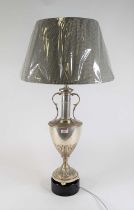 A silvered metal table lamp in the form of an urn standing on further ebonised base, height