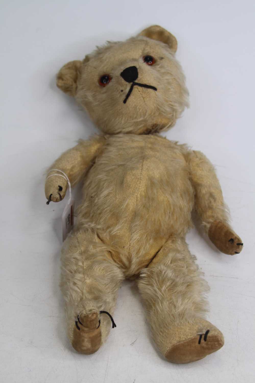 A vintage blond mohair teddy-bear, having opposable limbs and glass eyes, h.37cm In very poor