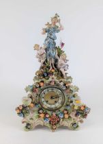 A continental pottery floral encrusted figural mantel clock, the enamel chapter ring with Arabic