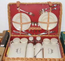 A mid 20th century picnic set, four place settings, comprising plates, flatware, flasks, containers,