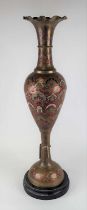 An Indian enamel decorated brass vase, having a frilled everted rim to slender neck and baluster