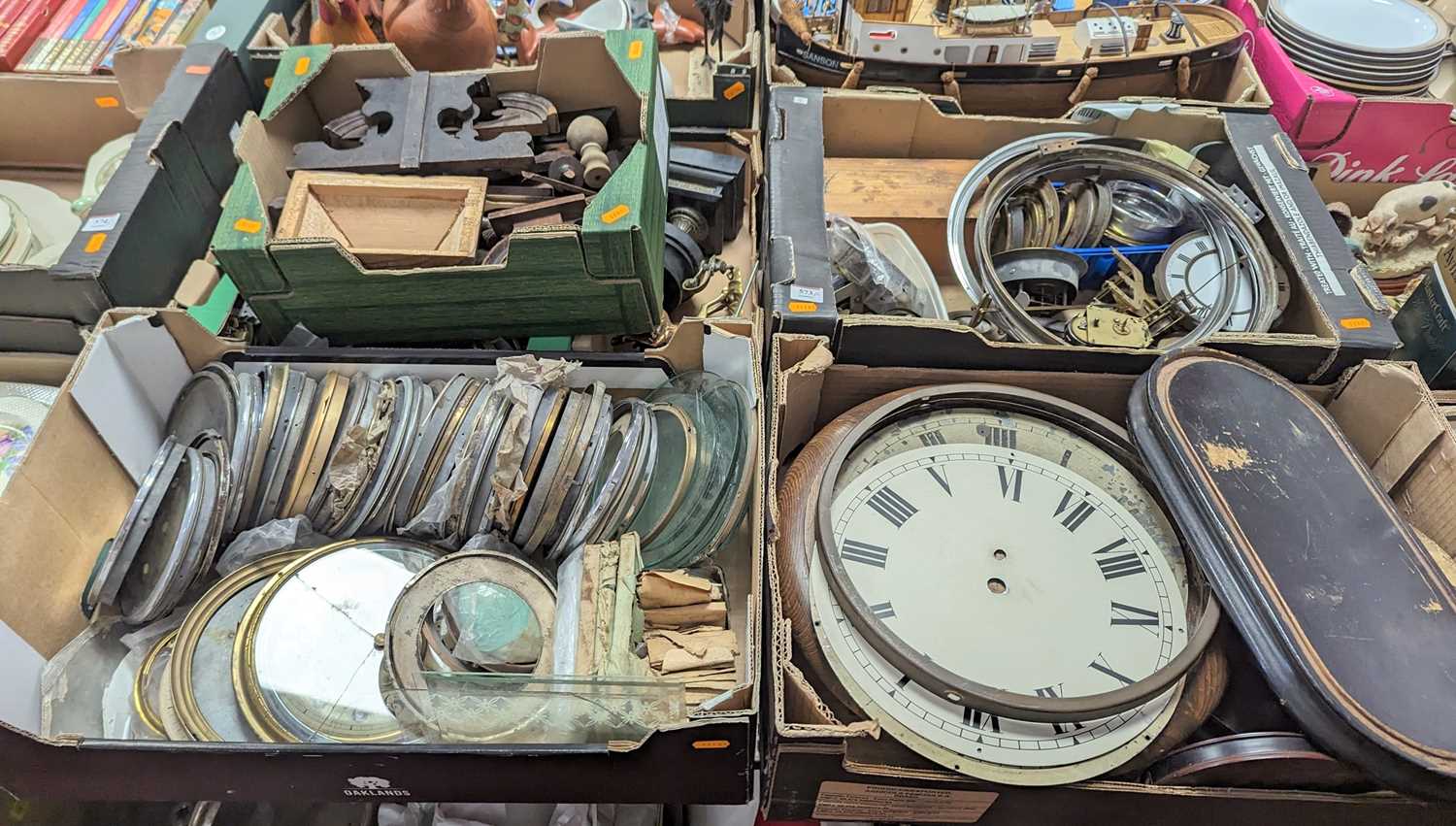 Five boxes of antique clock parts, to include dials, movements, bezels etc