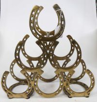 A novelty metal six-bottle wine rack, in the form of horseshoes, h.40cm