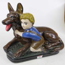 A plaster model of a boy beside a German shepherd dog, repainted, h.30cm