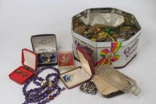 A tin of assorted costume jewellery to include beaded necklaces, brooches, etc