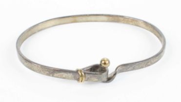 A Tiffany silver and yellow metal mounted bangle, 12.3g, dia.6.5cm Heavily tarnished but no apparent