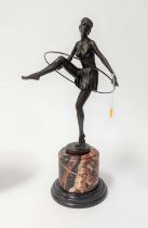 An Art Deco style bronzed metal figure of a dancer, mounted to a cylindrical polished hardstone