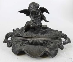 A 19th century French encrier, the cover surmounted by a seated putti, lifting to reveal inkwell