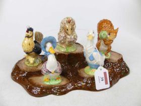 A set of five Beswick Beatrix Potter animal figures, with treestump display stand (6)